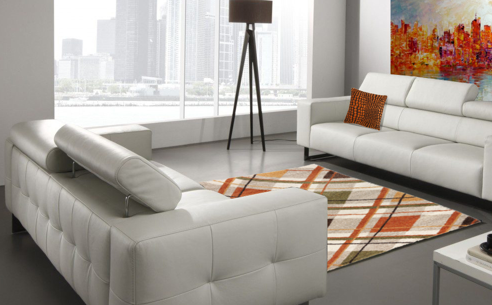 Salón moderno, con sofás blancos enfrentados, unidos por una alfombra de formas geométricas